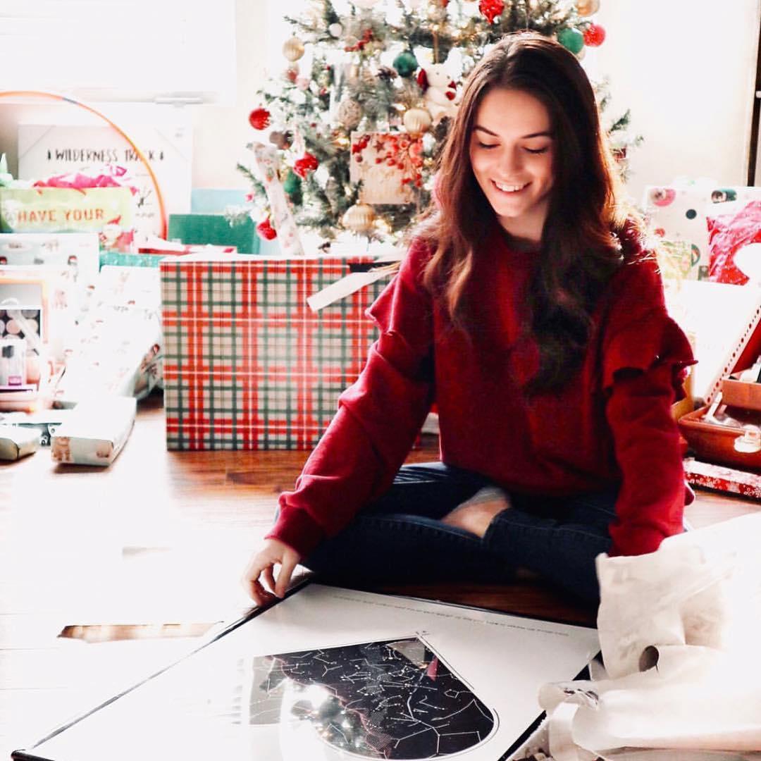 Lady smiling as she unboxes a star map on the floor